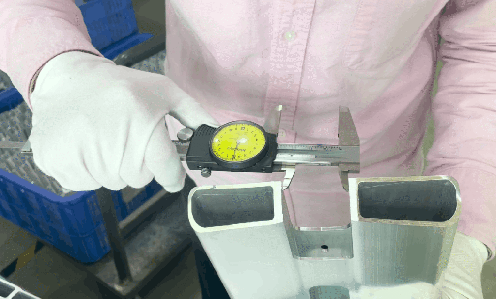 Aixi Sports quality control specialist measuring stunt scooter deck dimensions with precision digital caliper for quality assurance